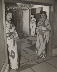 War era prositutes in traditional dress stand at a brothel doorway